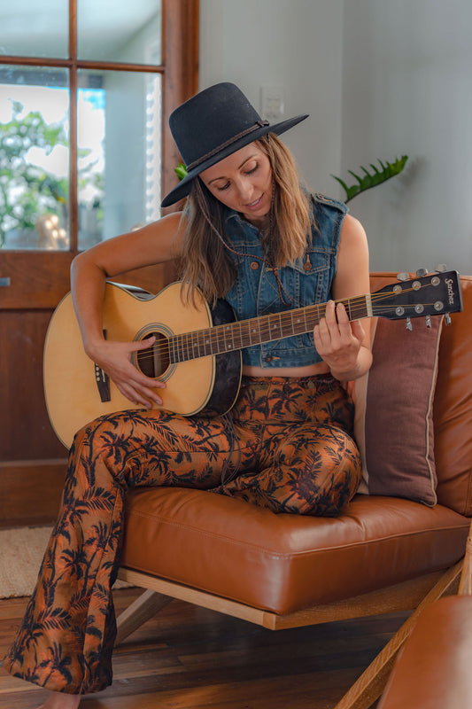 Image of model wearing the Levis denim vest with flares playing the guitar