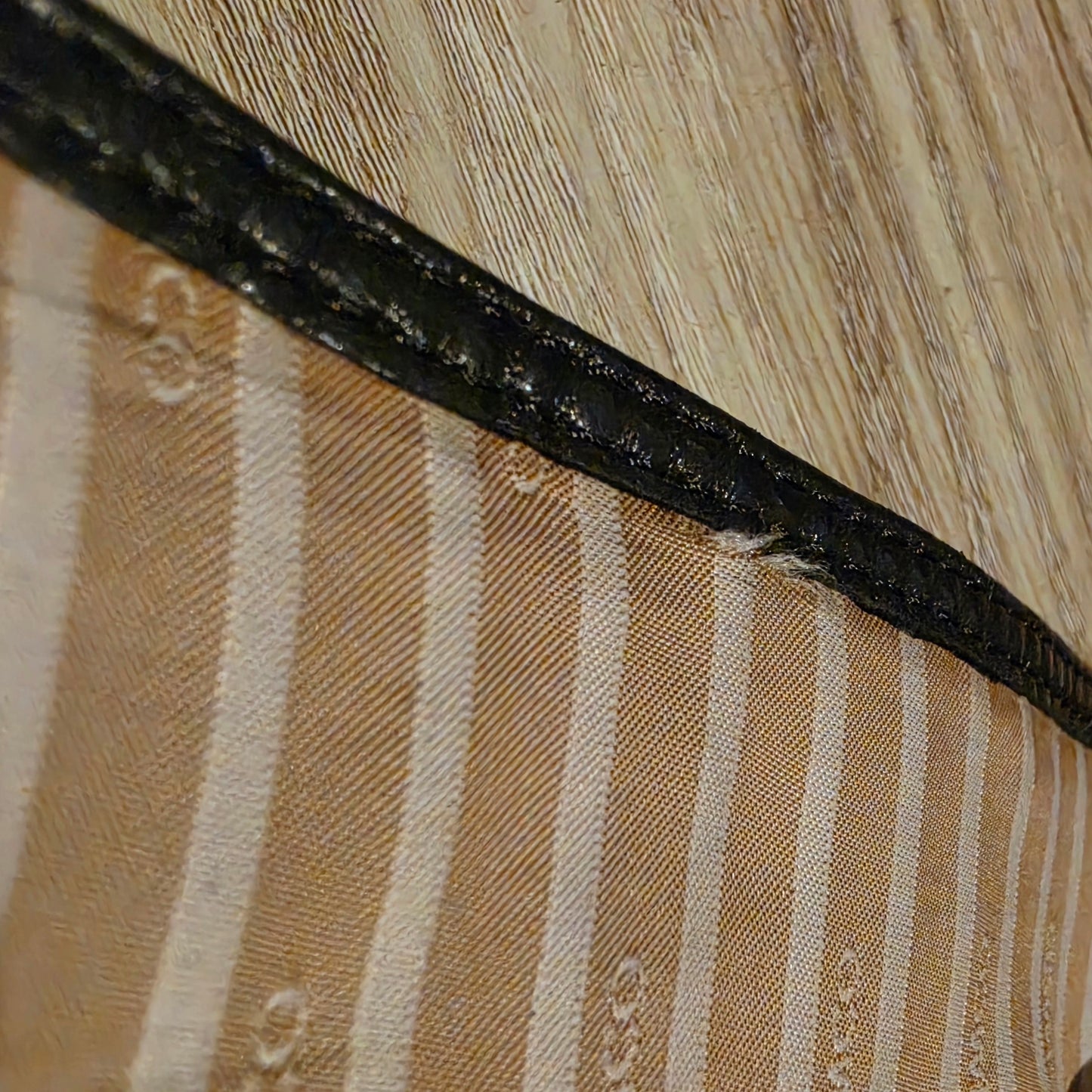 Image of the inside of the Mimco leather wrap belt showing an area where the lining is coming away from the leather stitching.