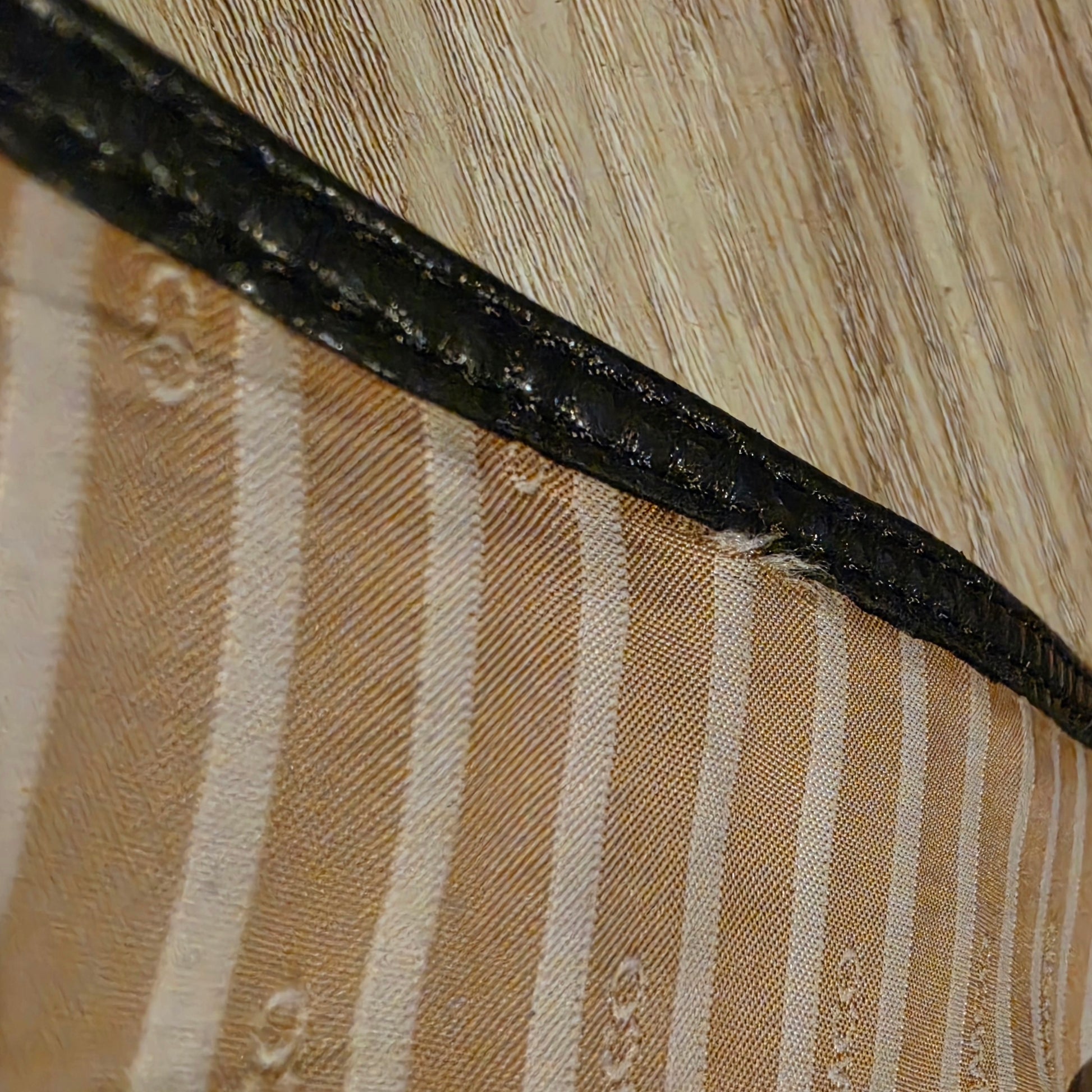 Image of the inside of the Mimco leather wrap belt showing an area where the lining is coming away from the leather stitching.