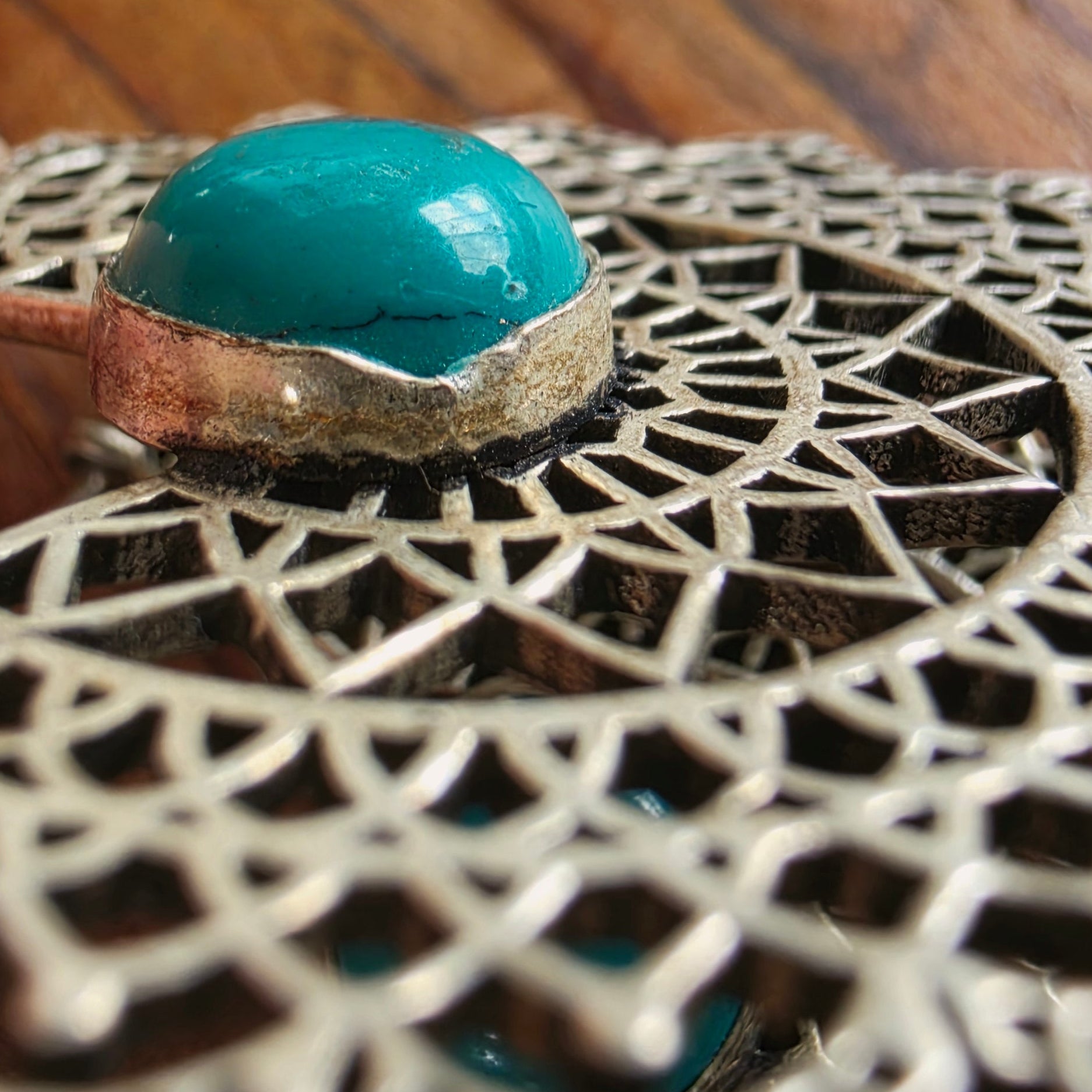 Close-up of a turquoise coloured stone pendant on the MIrage filigree earrings