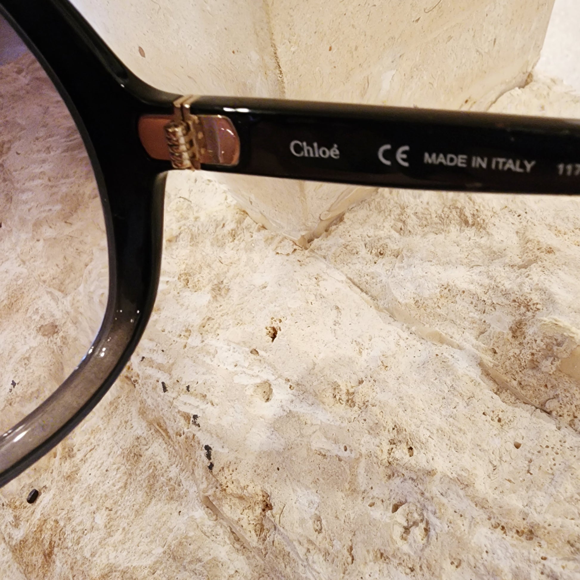 Close up of Chloe sunglasses showing the brand on the temple and made in Italy text.