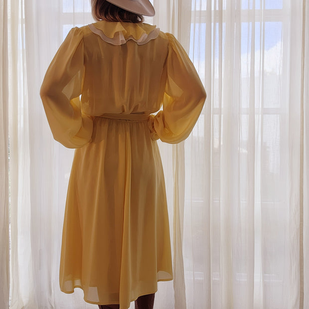 Vintage Peter Barron Dress in size 12. Lovely semi-sheer lemon colour with a ruffle neckline and tie belt. Available online now at wilsonavenue.au