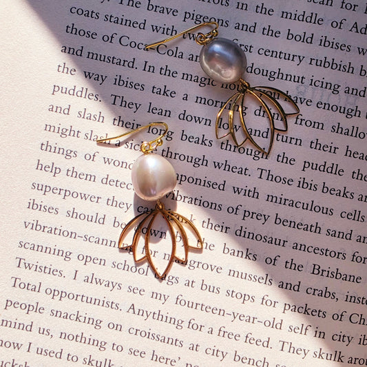 Image showing the Qoqa pearl and gold-toned statement earrings on book background.