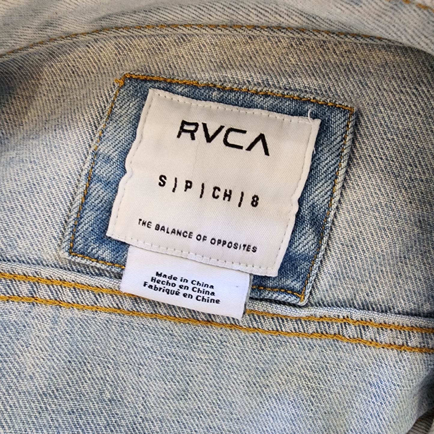 Image showing the inside label brand and size Small on the RVCA denim jacket