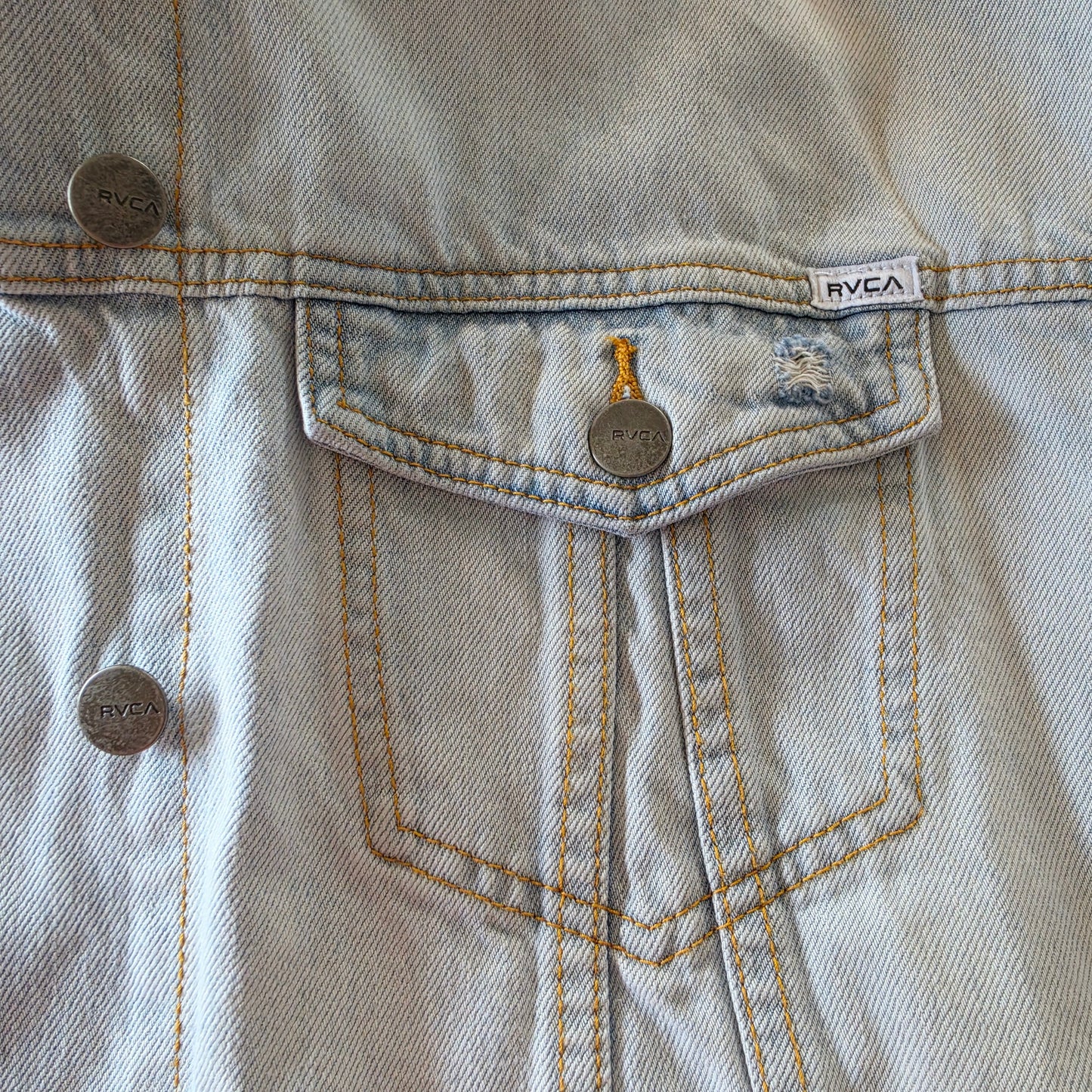 Image showing the ocket detail and brand name on the RVCA distressed denim jacket.