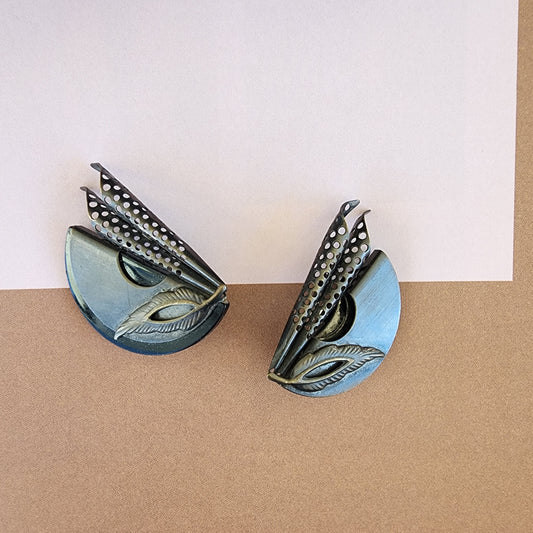 Close up of the front of the sculptural art deco clip on earrings, showing the slight surface scratches