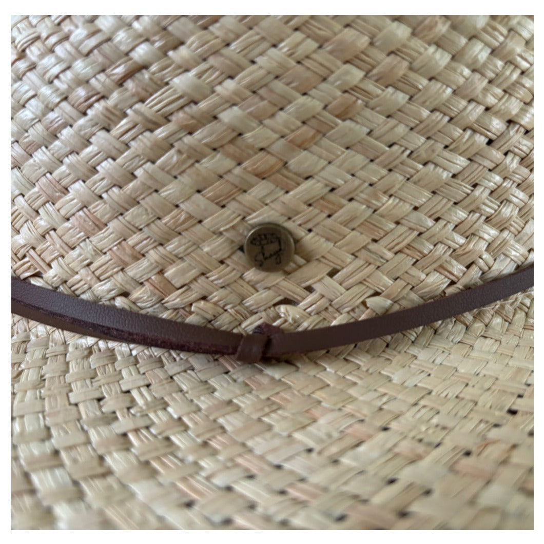 Close-up of the Shayd Mini Straw Hat showing the brown band and logo