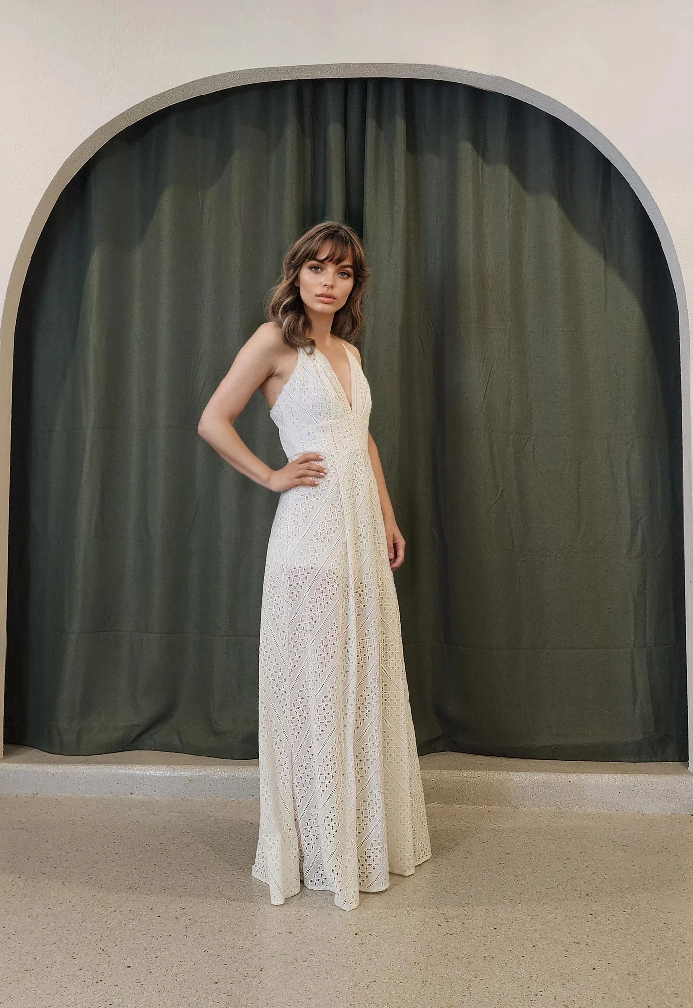 Model side on, in the Sheike Arabesque Maxi Dress, showcasing the deep V neckline and full-length silhouette in eyelet lace.