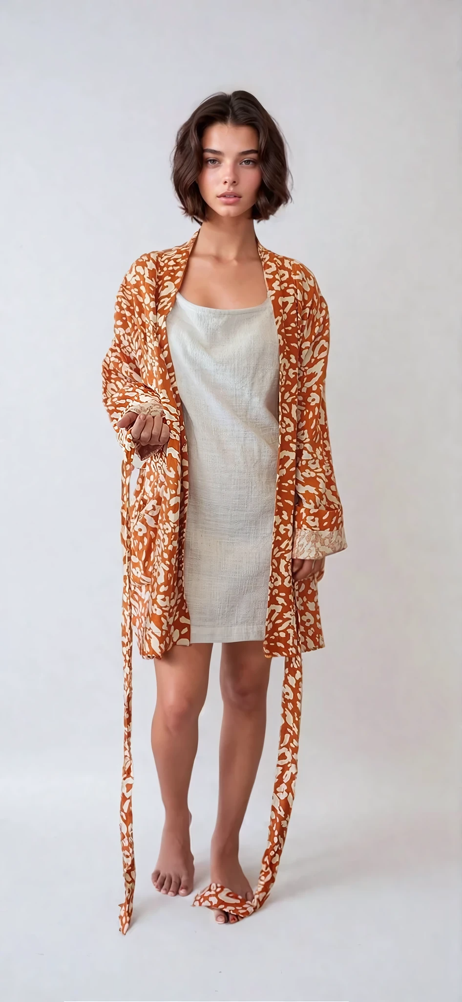 Front view of model wearing The Travelling Kimono recycled linen kimono in rust coloured  leopard print size small.