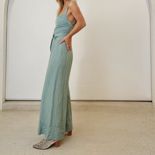 Side profile of the Tigerlily Hana Jumpsuit. Showing the clean lines and natural drape of the linen fabric, styled with snakeskin mules.