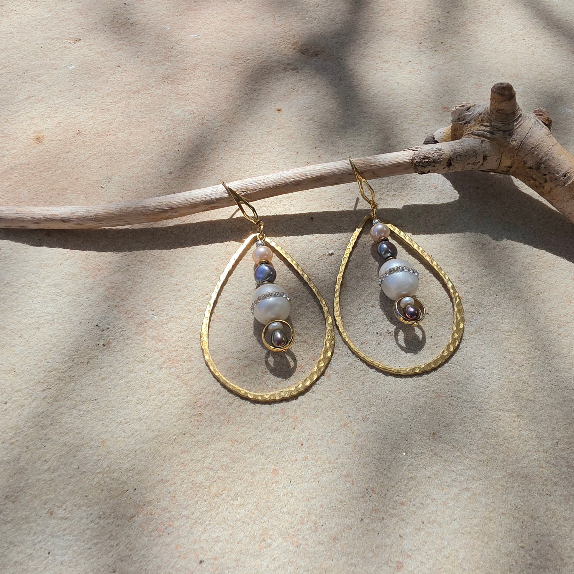 Top view of the Versamel earrings, showing the different coloured pearls, diamantes, brass and gold plated components