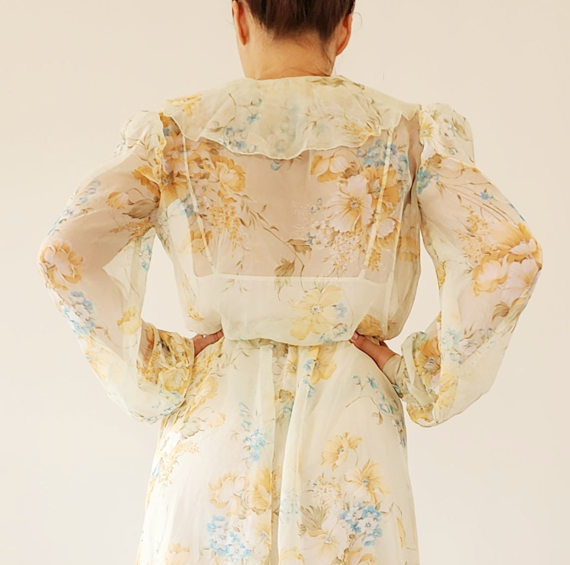 Close-up view of model wearing the vintage floral 70s dress, showing the sheer fabric and wide soft floaty collar.