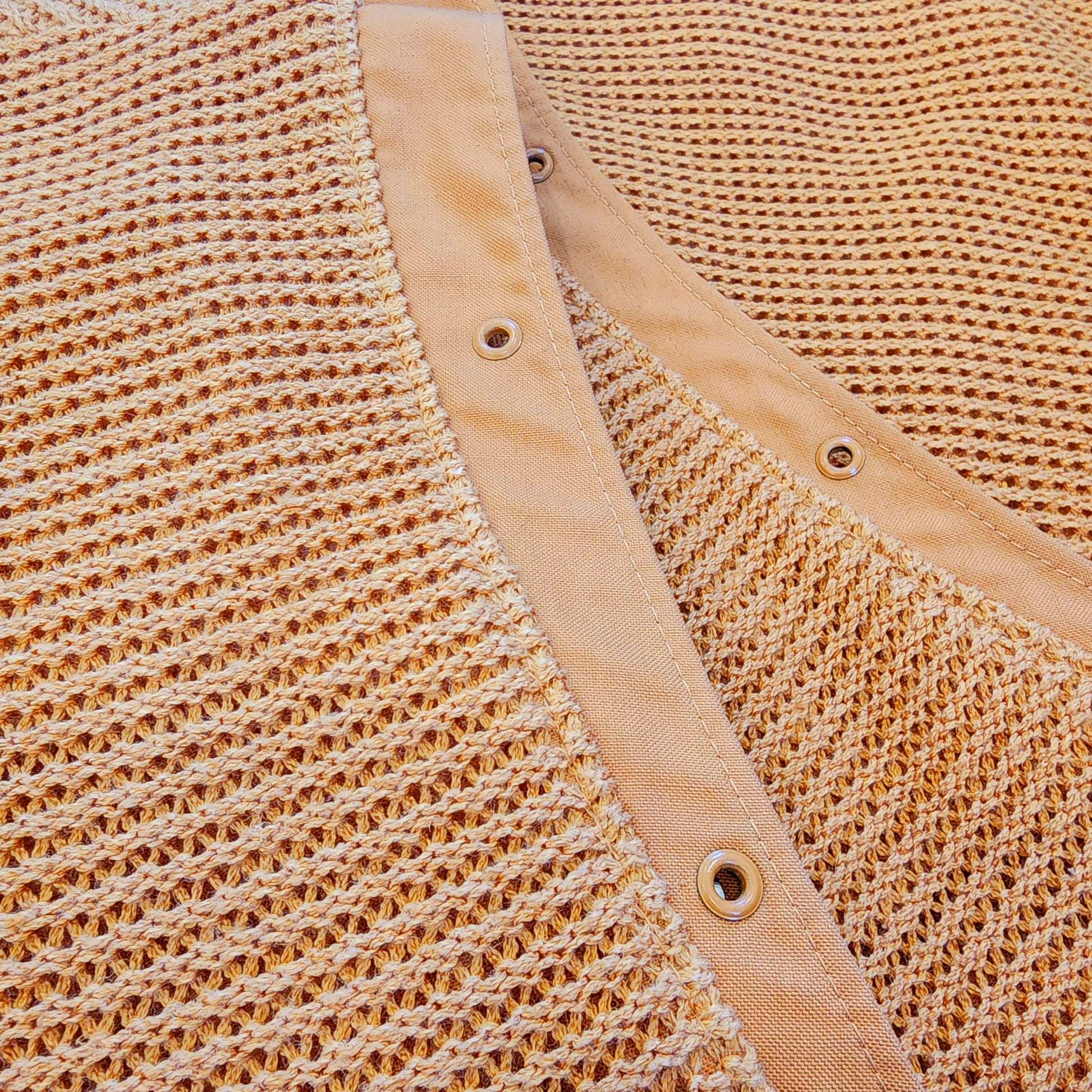 Close up view of woven fabric and the stud details on vintage Ara Modell vest