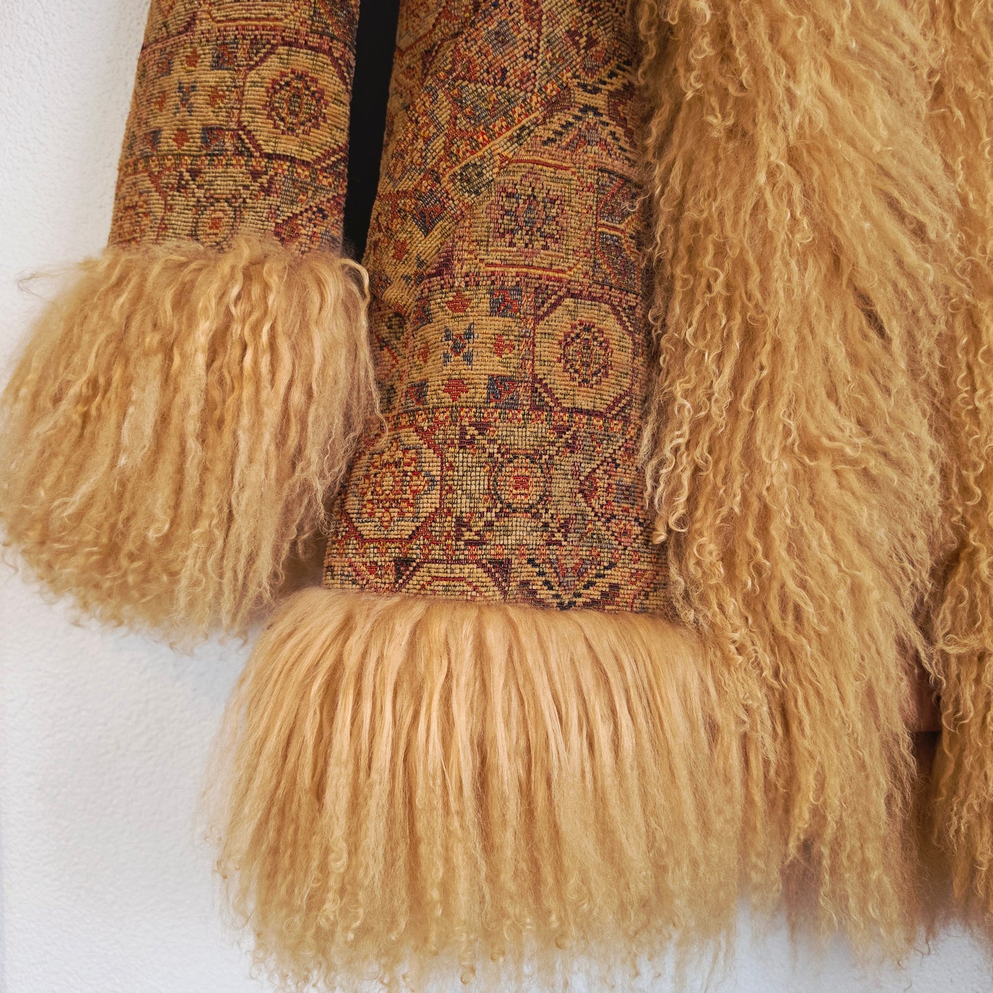 A close-up of the Vintage Penny Lane Tapestry Coat, showing the Mongolian Sheep trim, the pocket and the bohemian design on the fabric