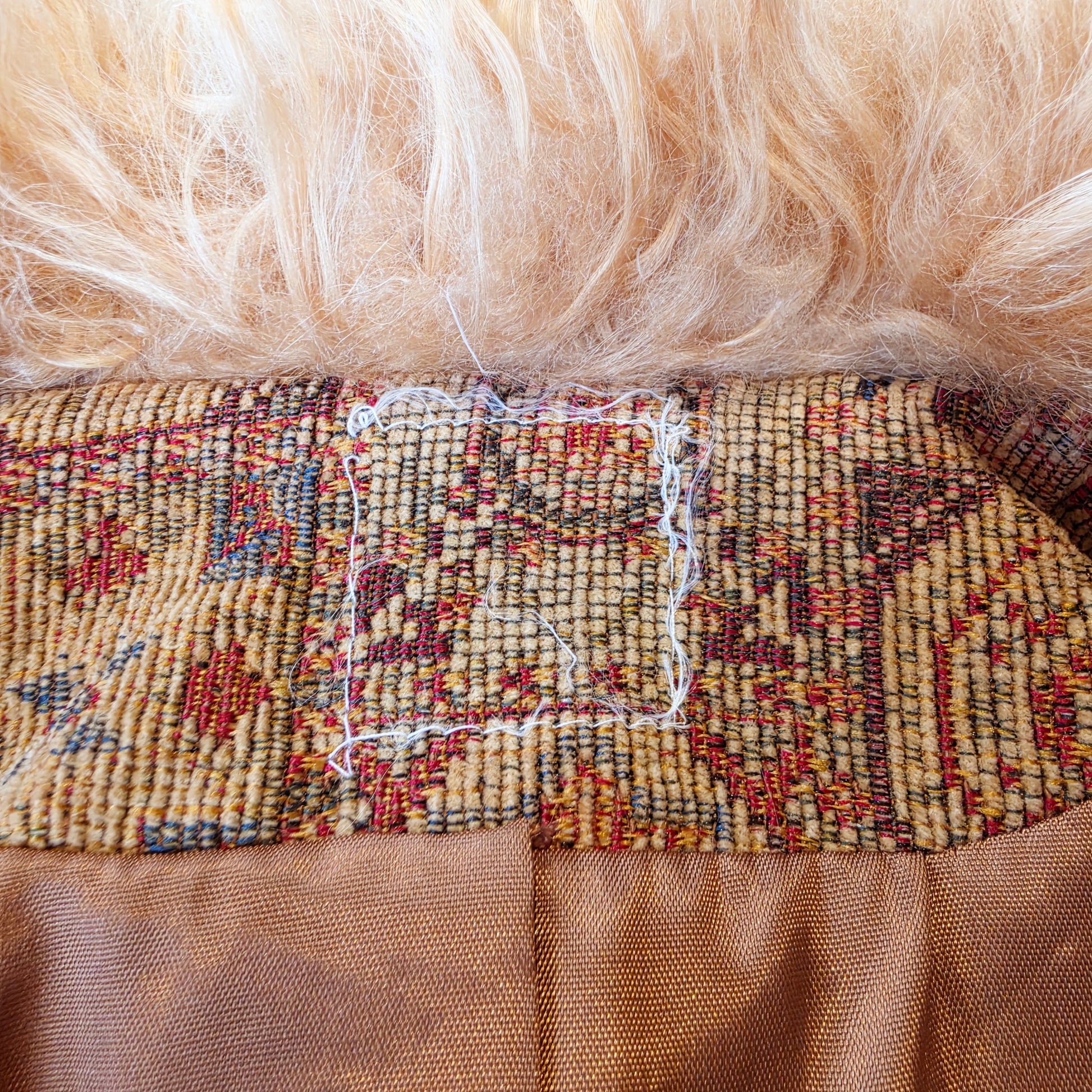 close up iew of the remaining thread form the missing label in the vintage Penny Lane Tapestry Coat with Mongolian Sheep trim