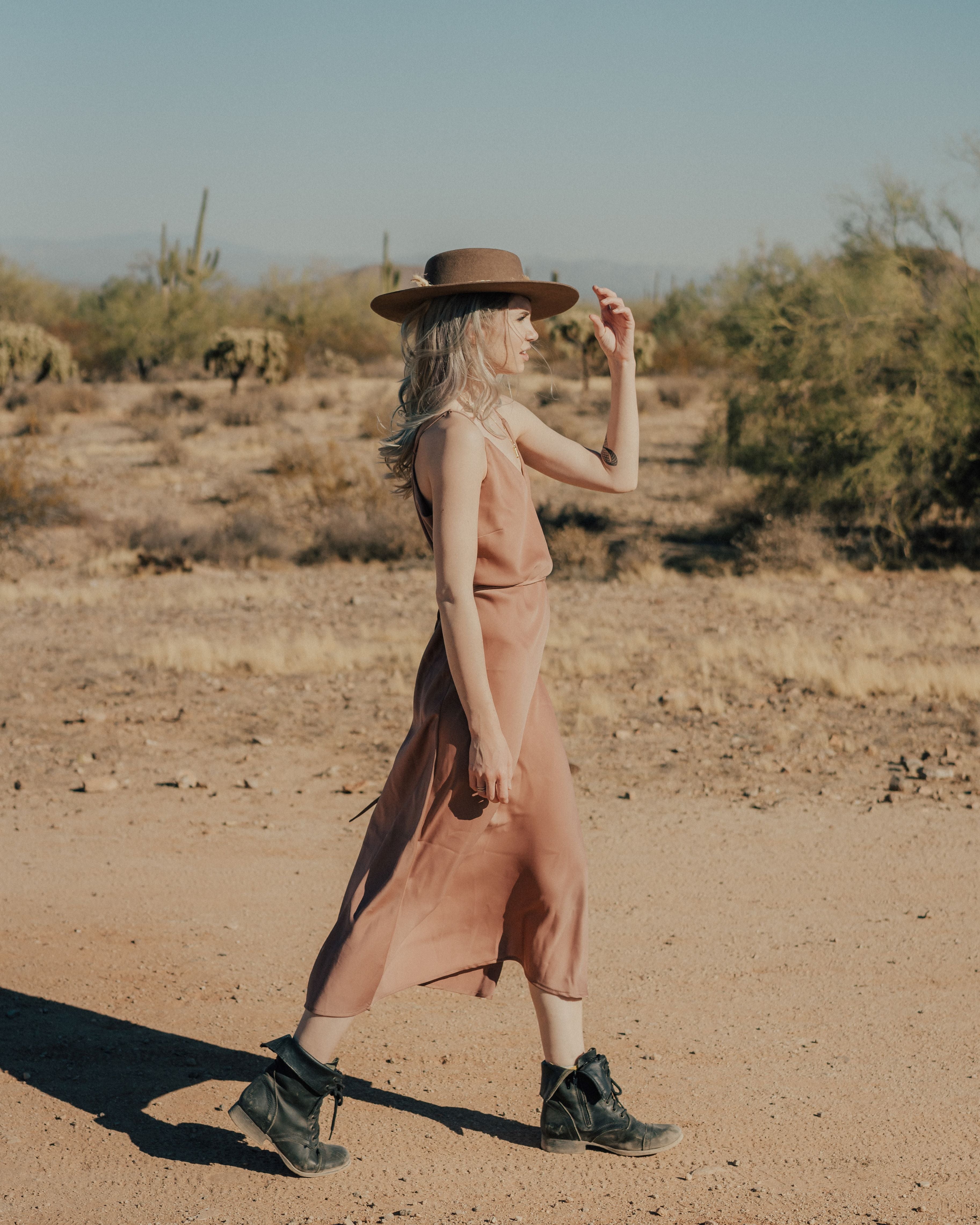Desert style bohemian girl in a ilk slip, boots and western hat