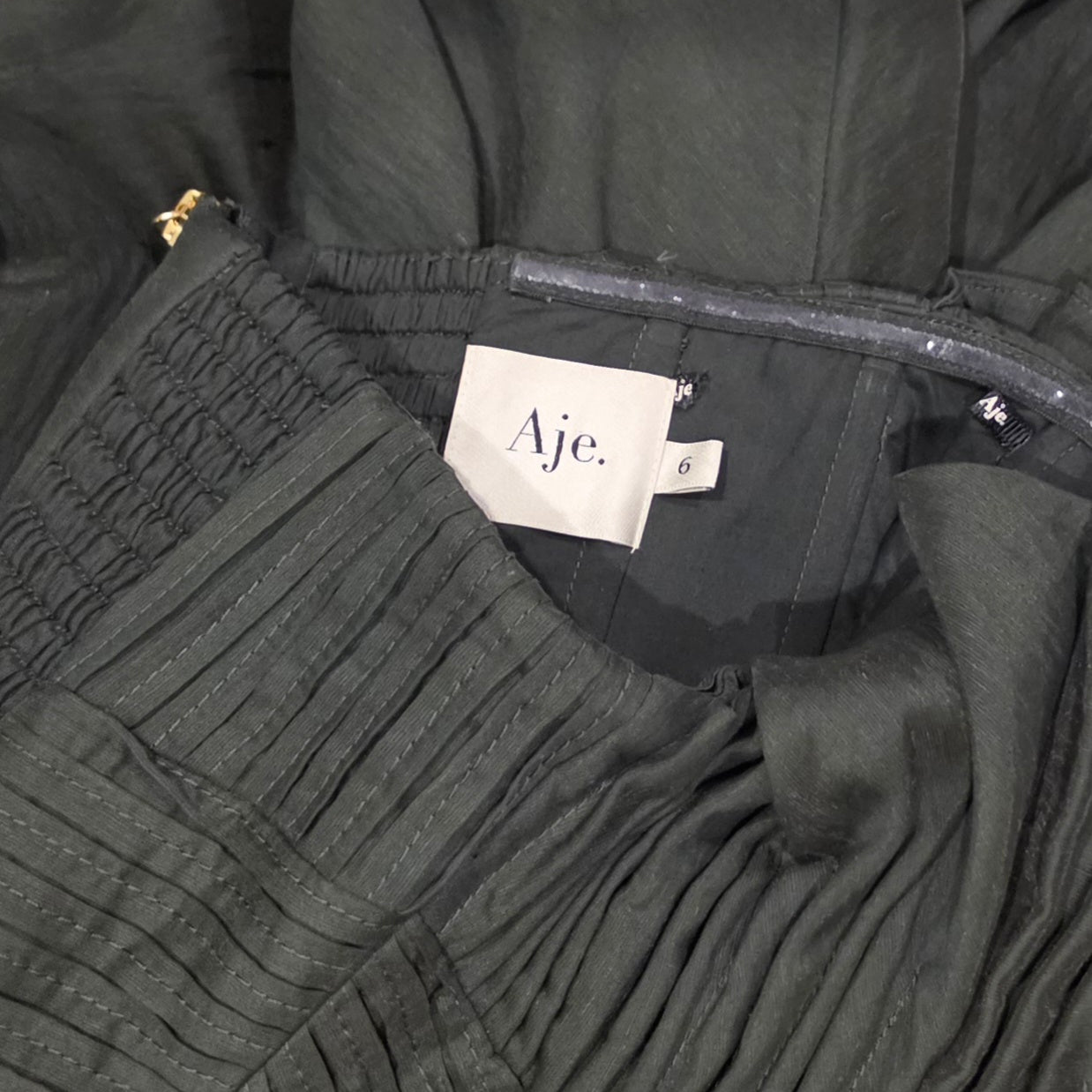 Close up image of the Aje label and size 6 inside Aquiline gown, also shows the removed coat hanger ties