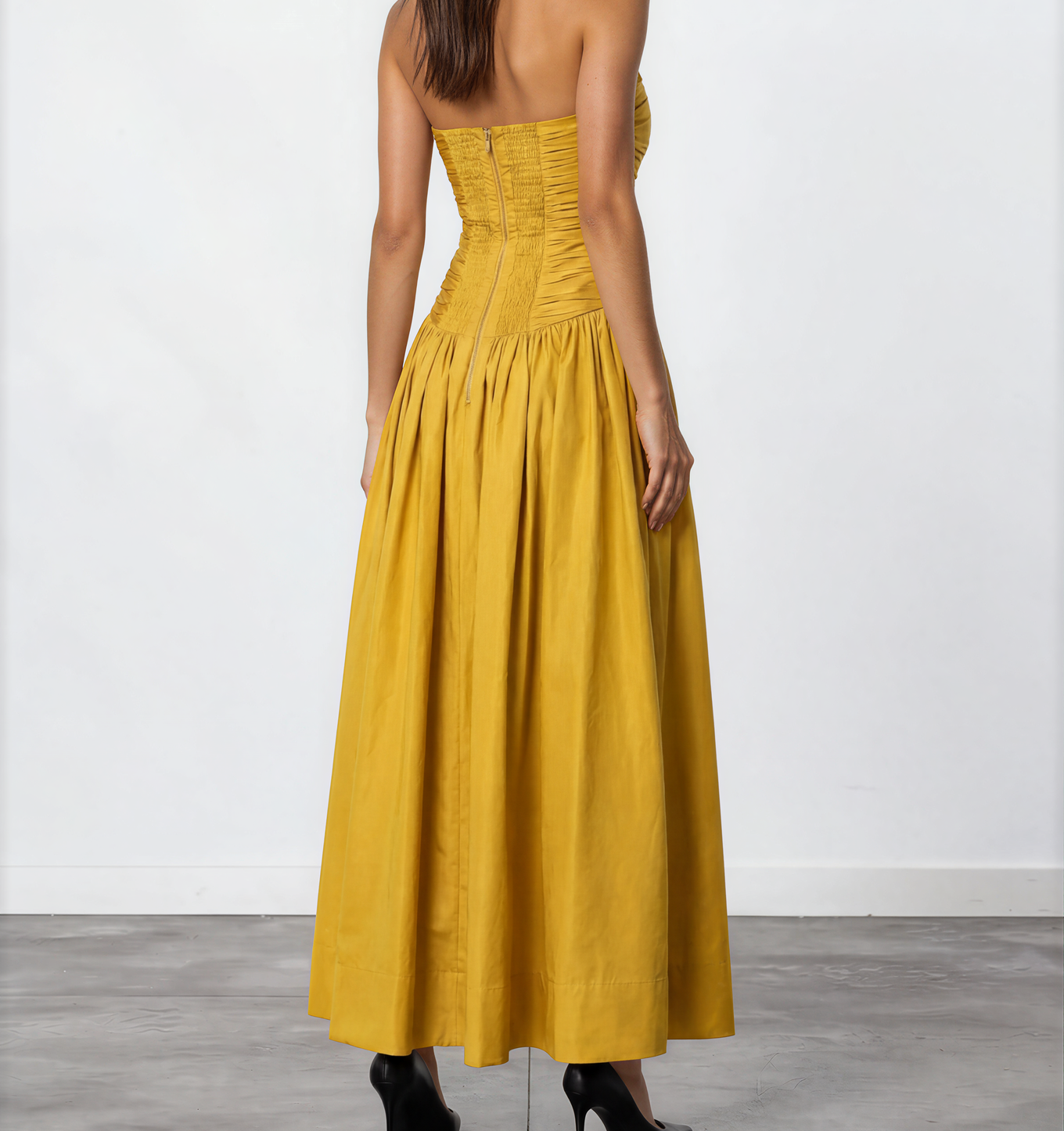 Back view of mustard yellow Aje Marigold strapless maxi dress with shirred panel and full skirt