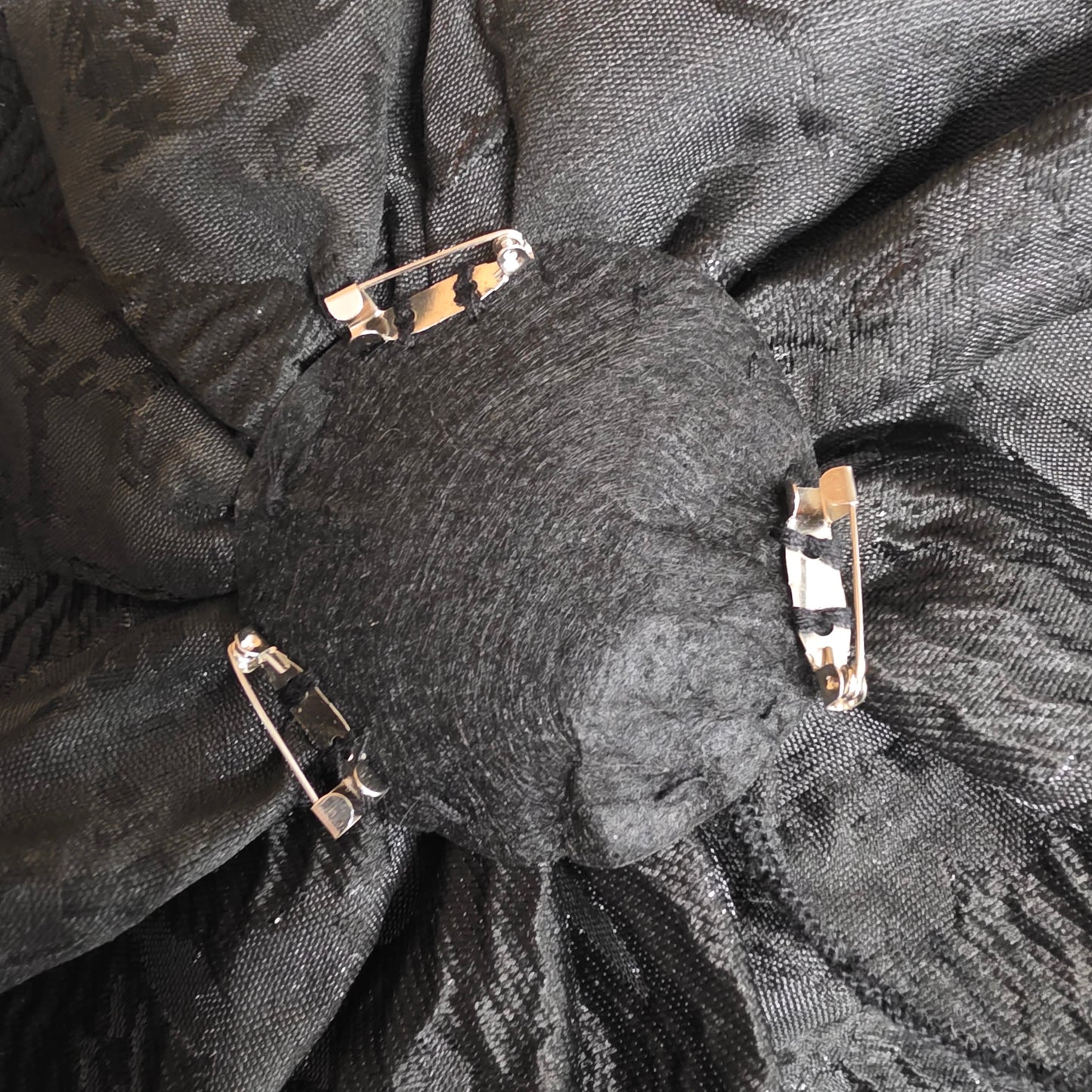 Back of the removable floral shoulder appliqués showing the secure pin fastening for versatile styling.