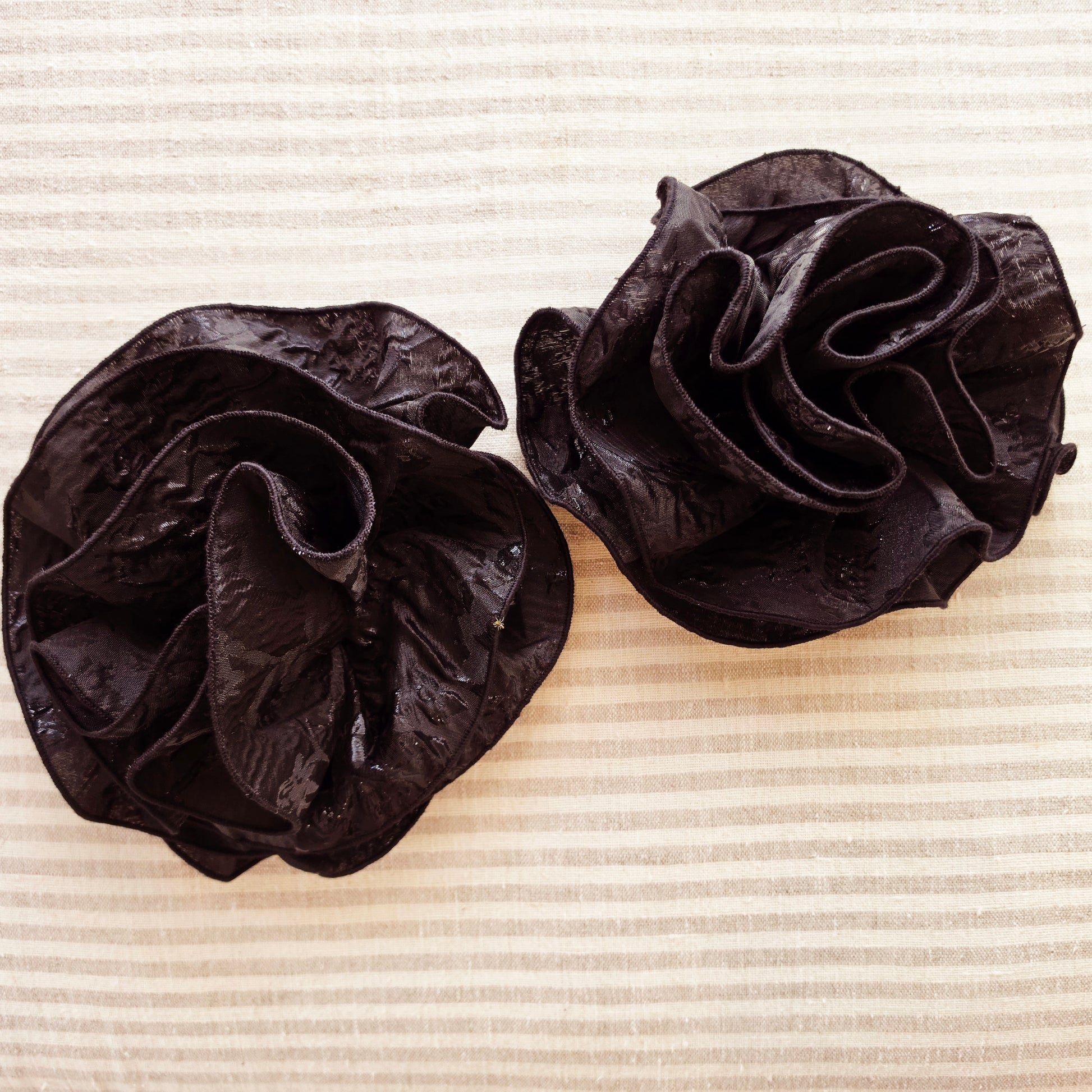 Close-up of the removable oversized floral shoulder appliqués from the Anissa one-shoulder black jacquard evening gown.