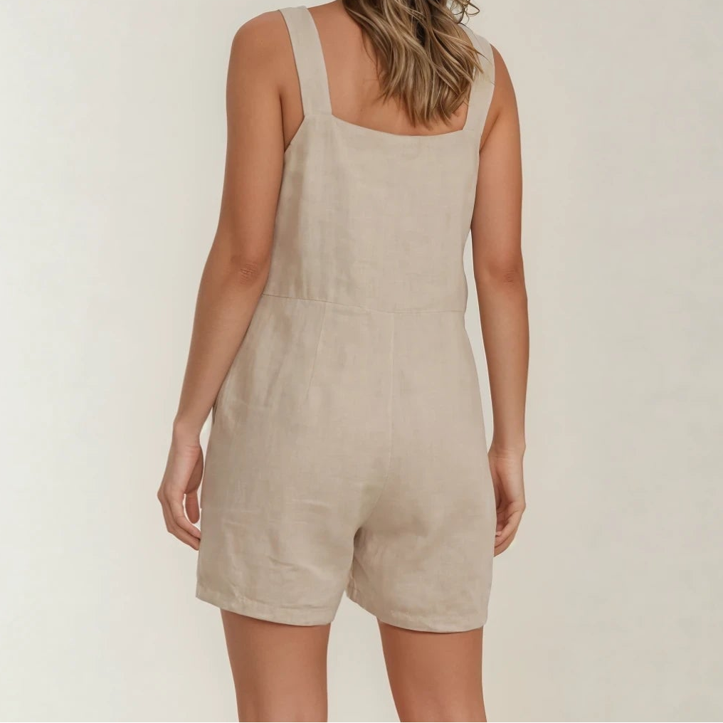 Model showing the back view of the beige Assembly Label playsuit.