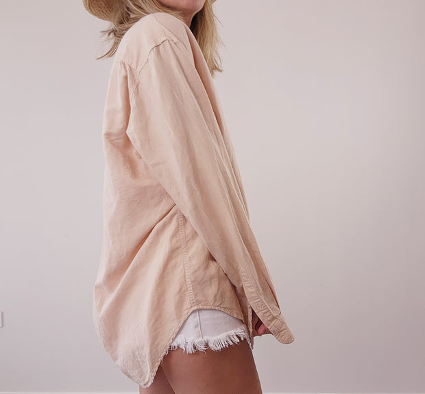 The side view of clothing brand Assembly label, button up long sleeve shirt.