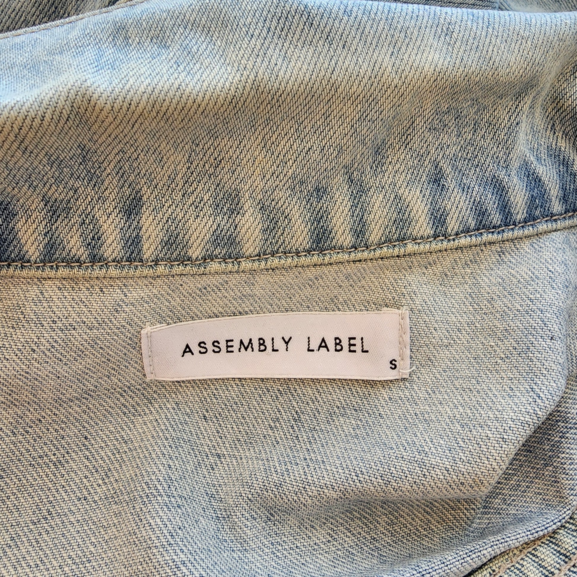 Image showing the inside brand label for the Assembly Label denim jacketand the size small.