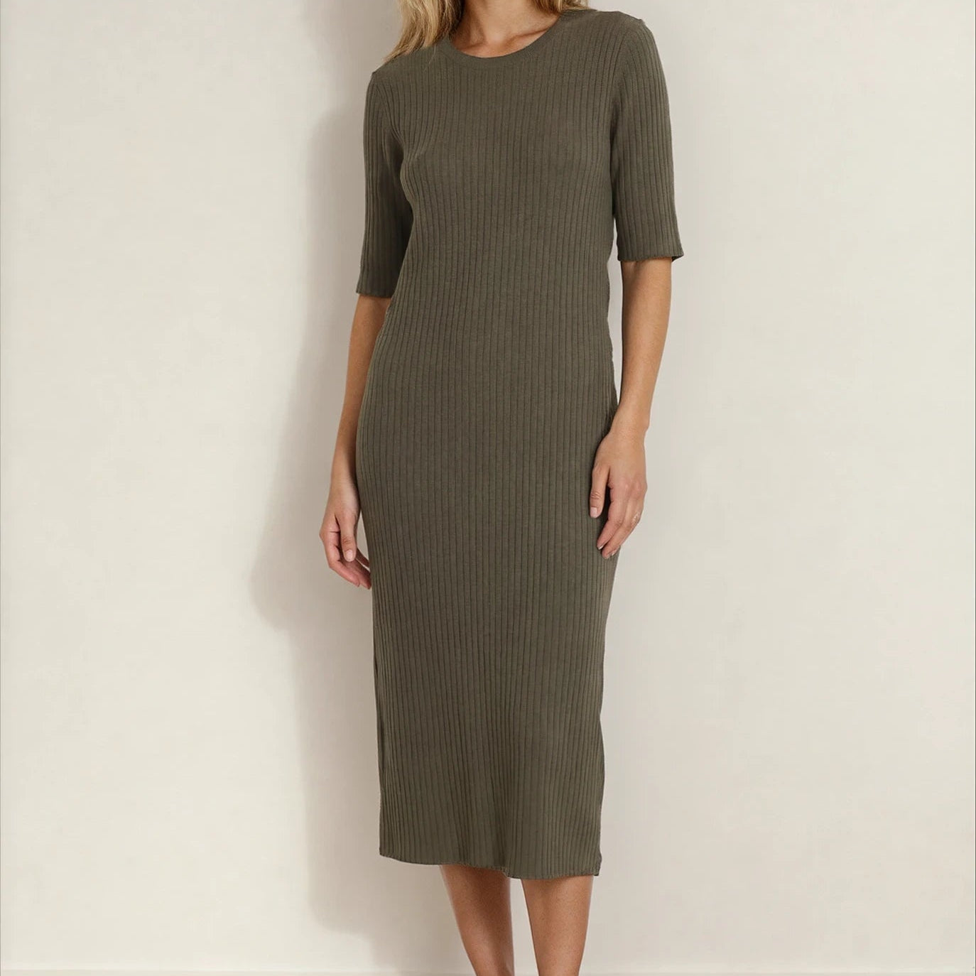 Front view of a woman wearing a green ribbed Assembly Label midi dress