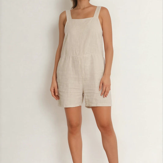 Model showing the front view of the beige Assembly Label playsuit.