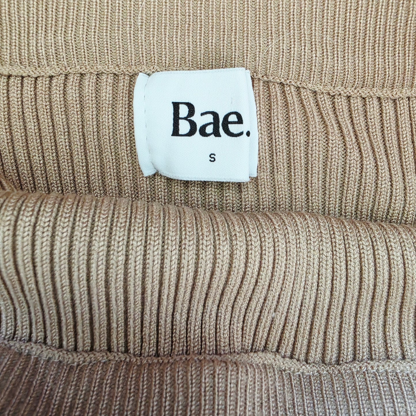 Close up image of the brand label for the BAE knit midi skirt showing the size S.