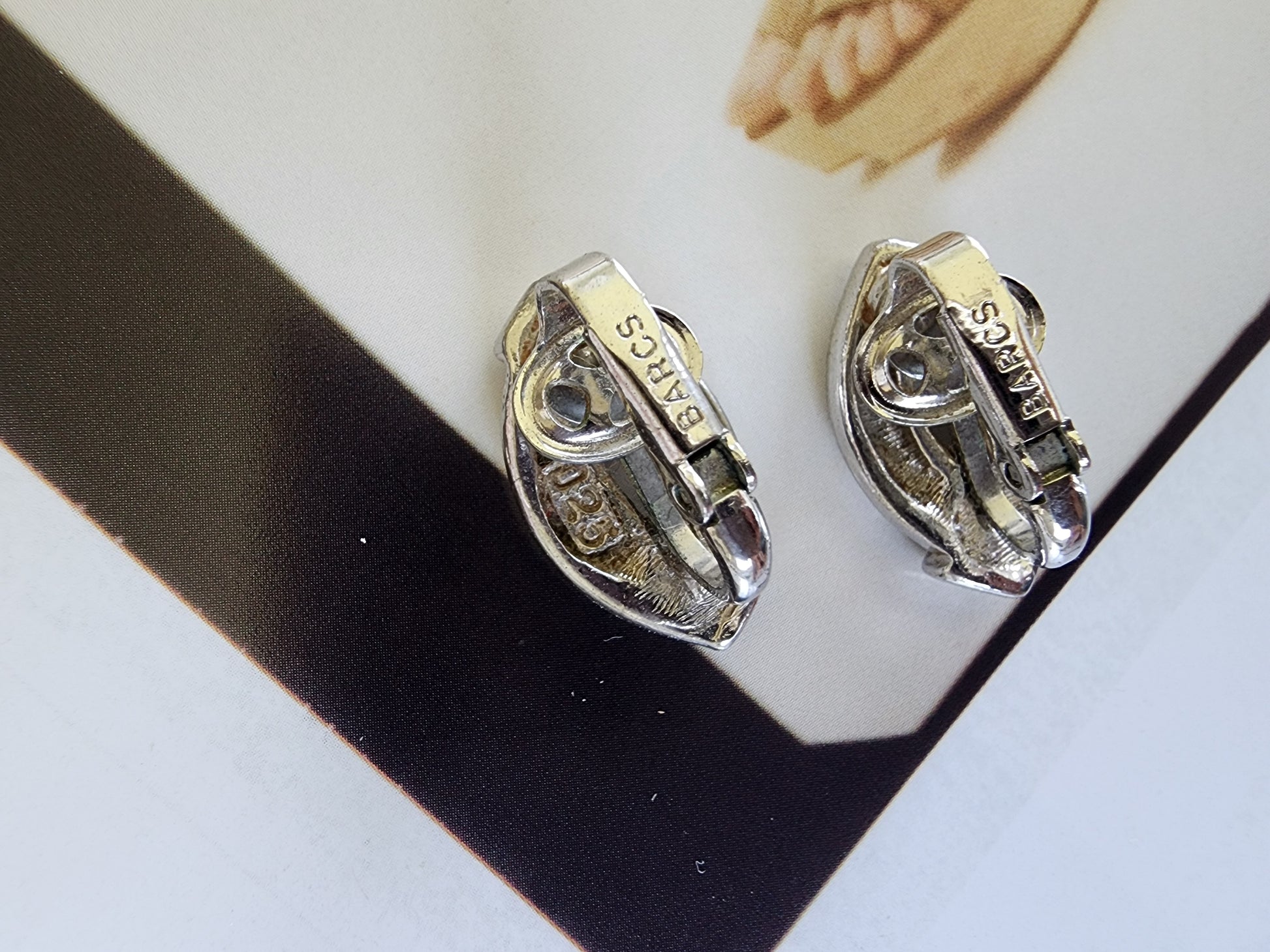 Back of vintage BARCS clip-on earrings showing stamped branding and hinge.