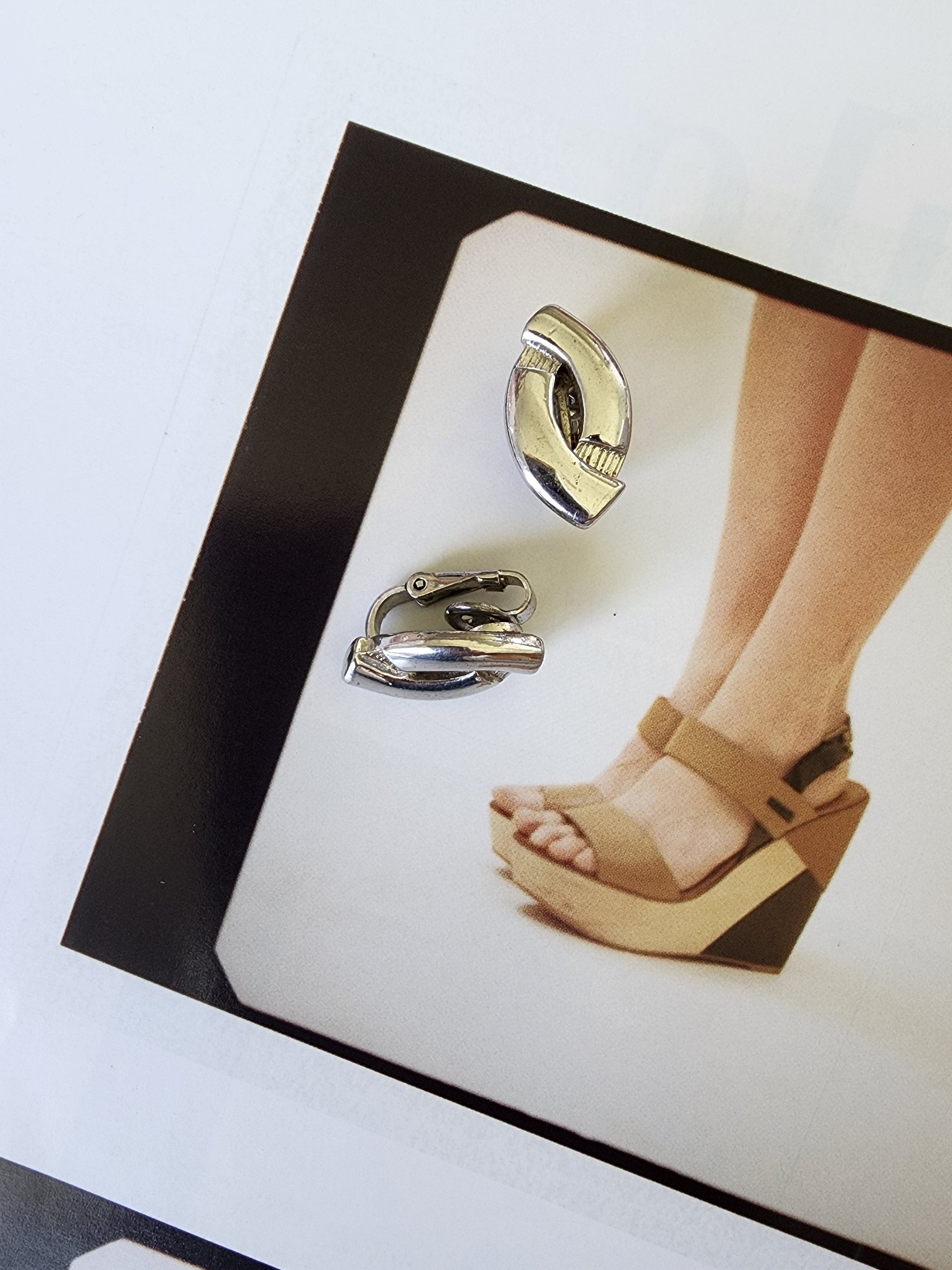 Front view of vintage silver-tone BARCS clip-on earrings showing their sculptural style and slight scuffing on metal.