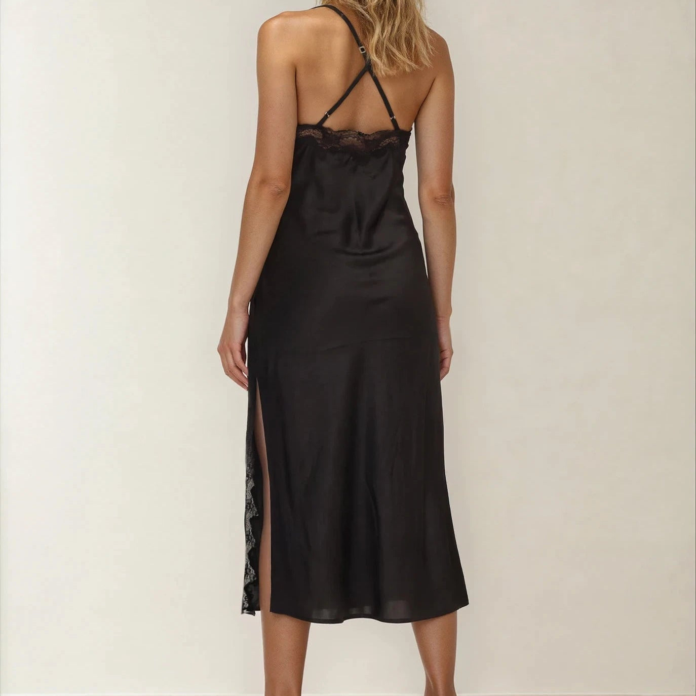 Back view of model wearing the Brans n Things Midi Slip dress showing the lace detail at the leg, across the back and the cross back straps.