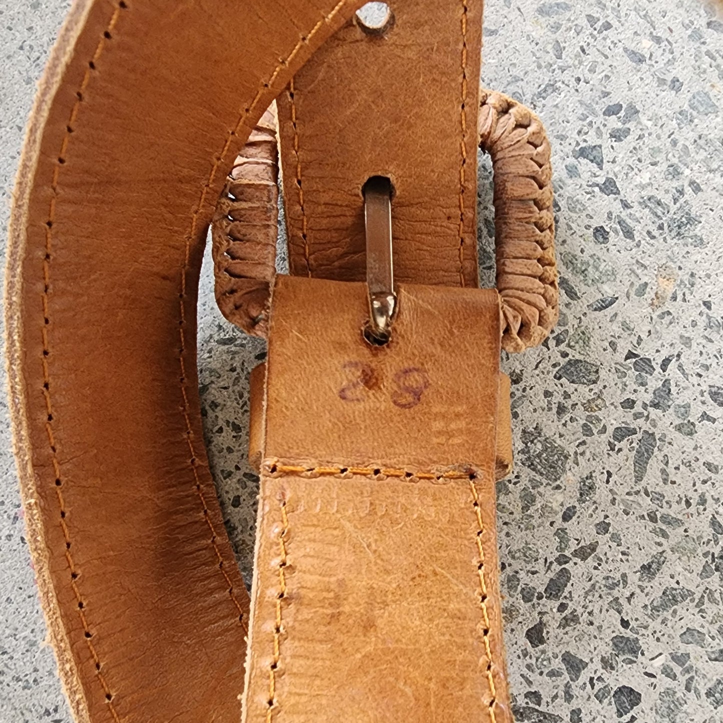 Close-up of Cielo Collective belt showing traditional woven textile panel, size and leather stitching detail.
