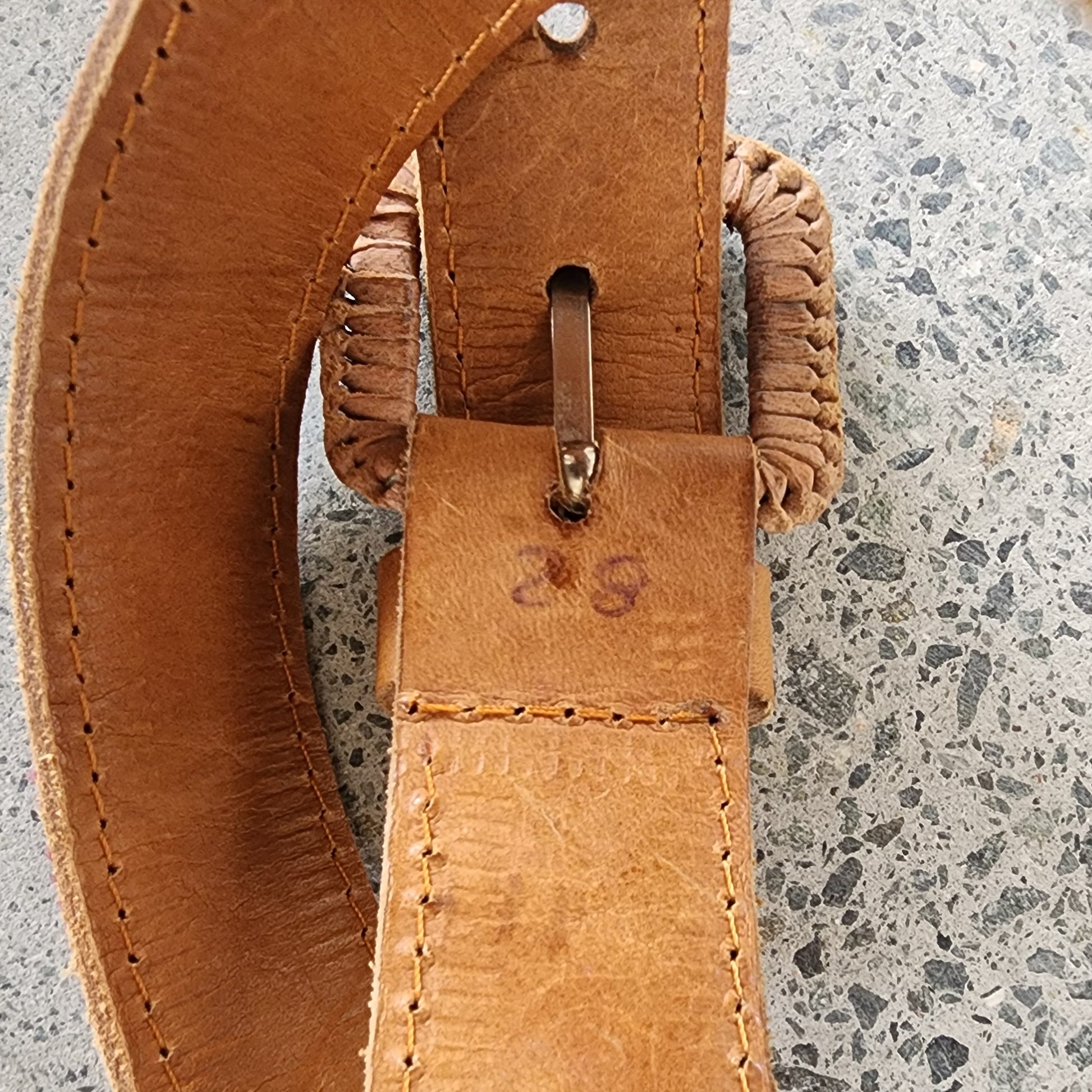 Close-up of Cielo Collective belt showing traditional woven textile panel, size and leather stitching detail.