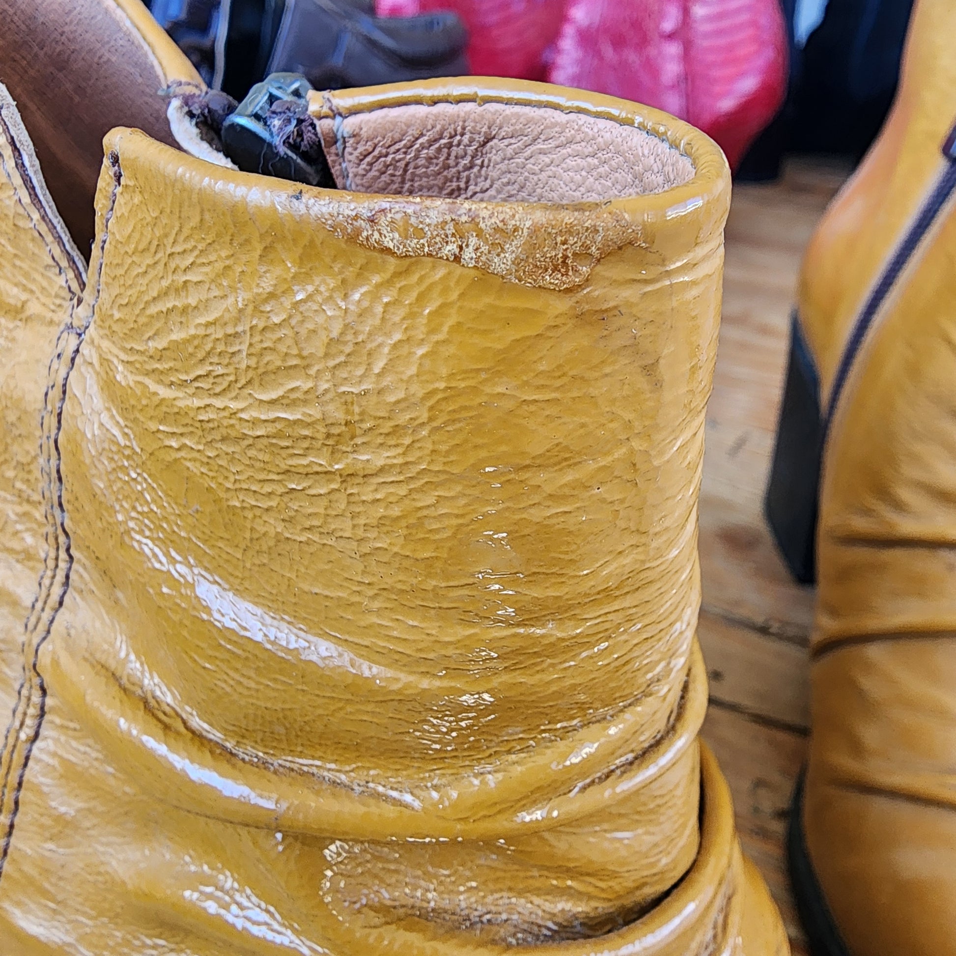 Close-up of the small glue mark on the top of the right mustard ankle boot from production.