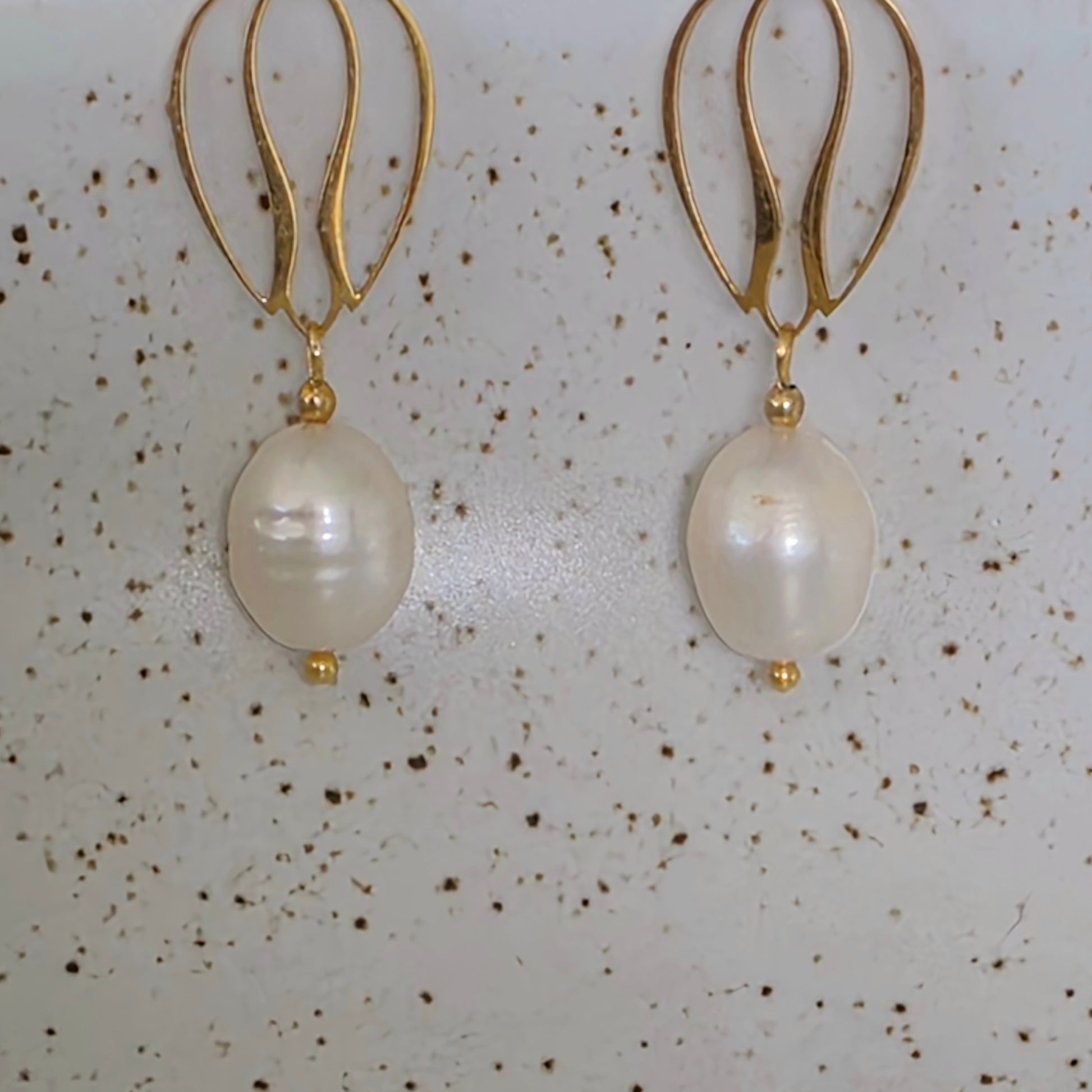 Close up view of the Dew handmade pearl earrings showing the luminous glow and uniquely shaped pearls