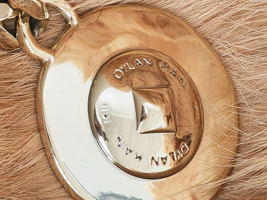 Close-up of Dylan Kain 88 chain belt gold medallion with surface scratching.