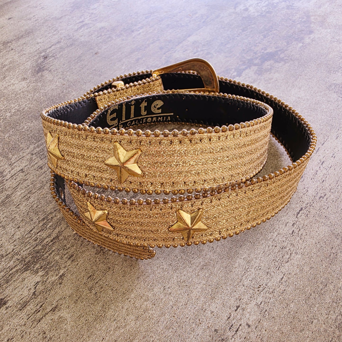 Vintage gold statement belt with star embellishments and textured metallic finish