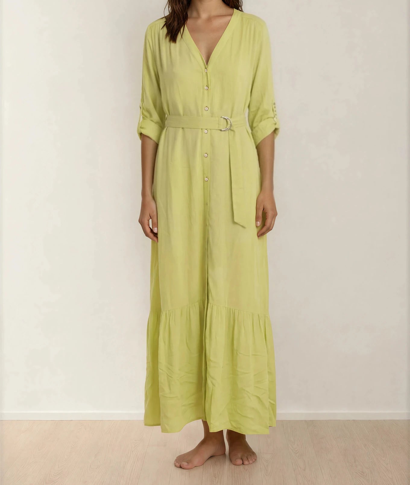 Model showing the front of the Eva Kayan button up dress, matching belt and tiered hemline.