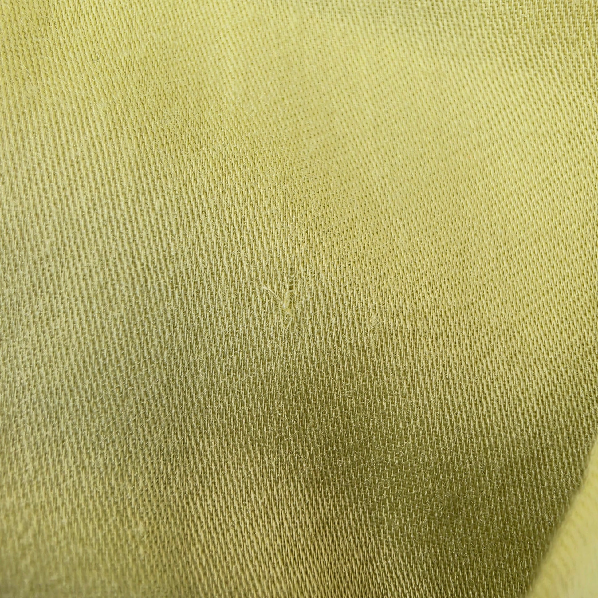 Close up view of the small pull in fabric on the inside lining of the Eva Kayan citrus coloured midi dress.
