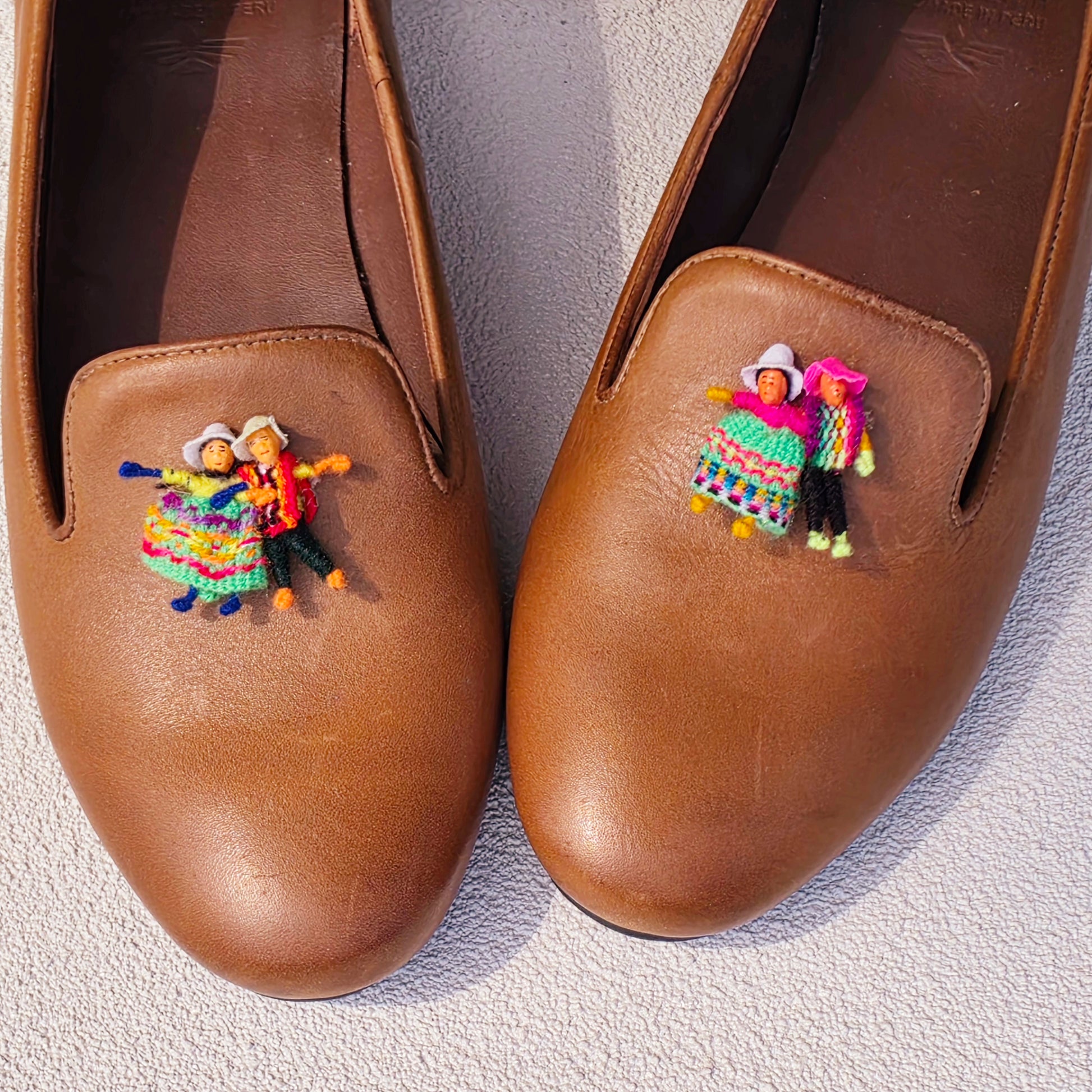 Close up view of the Fortress of Inca, smoking flats, showing the Andean doll details on each shoe and the tan leather loafer style.