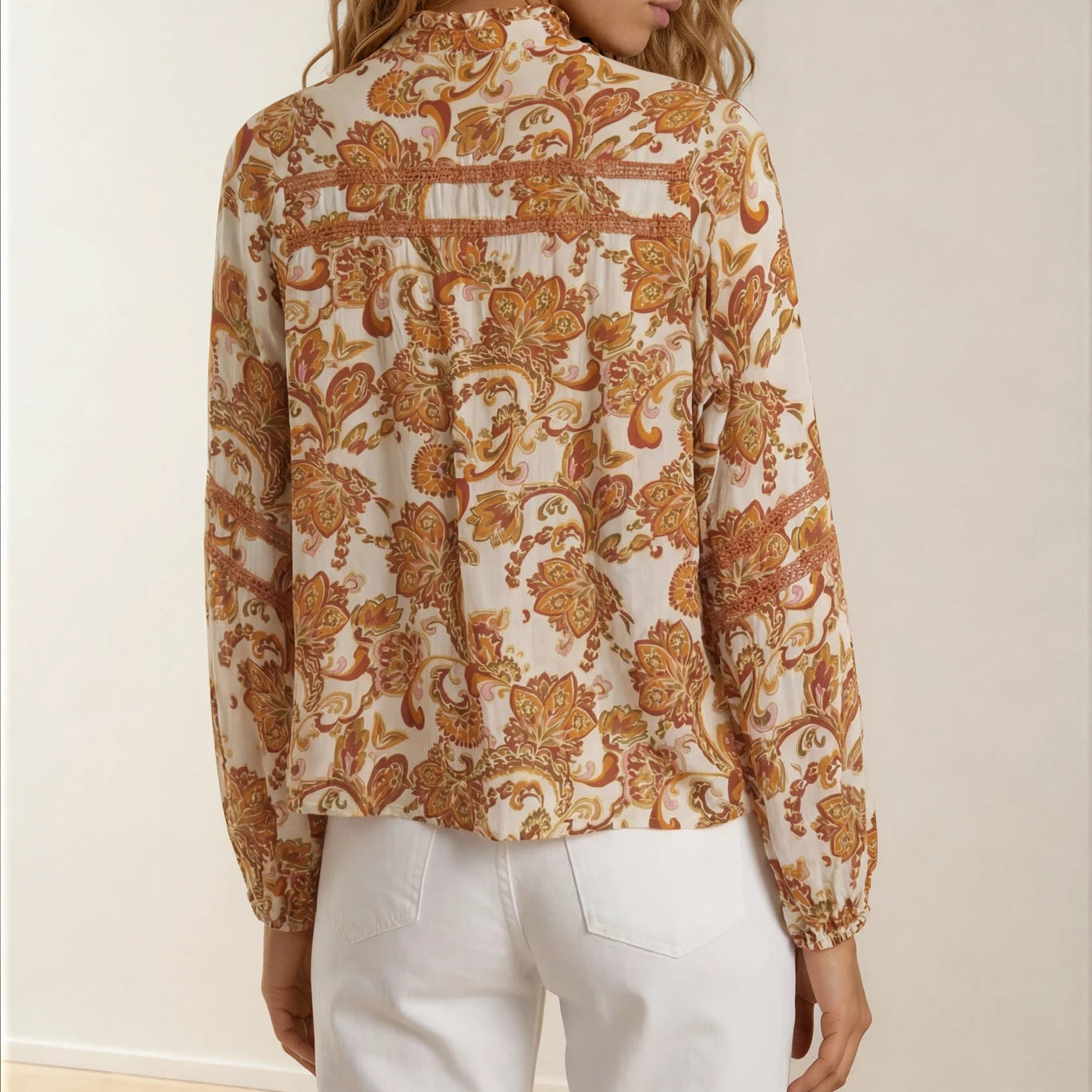 Model showing the back of the Gysette paisley button up, long sleeve top in Autumn colours.