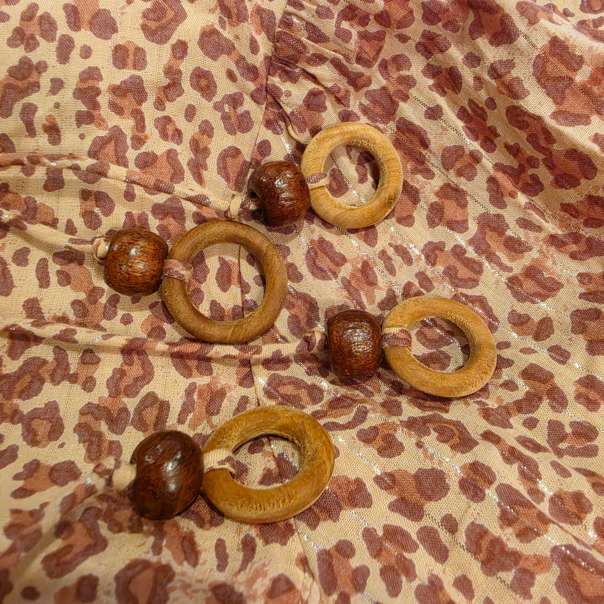 Image showing the bead details at the bottom of the front neck ties on the House of Skye animal print dress