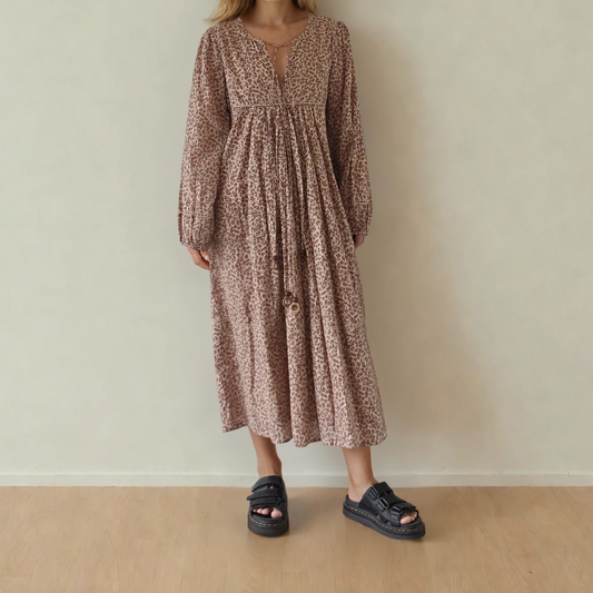 Image showing the front of the House of Skye animal print midi dress, showing the longer sleeve and beaded neck ties.