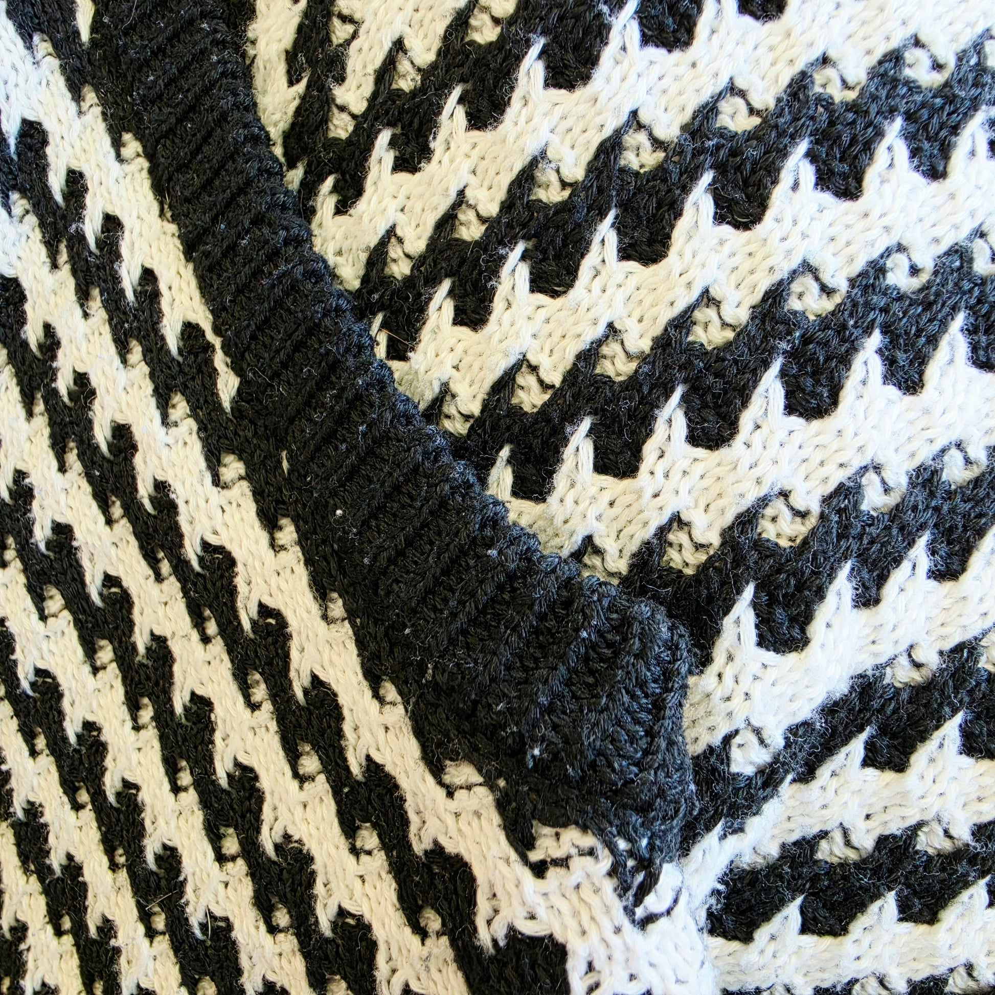 Close-up of underarm of the monochrome Indi Luxe knit dress showing the slight pilling and wear.