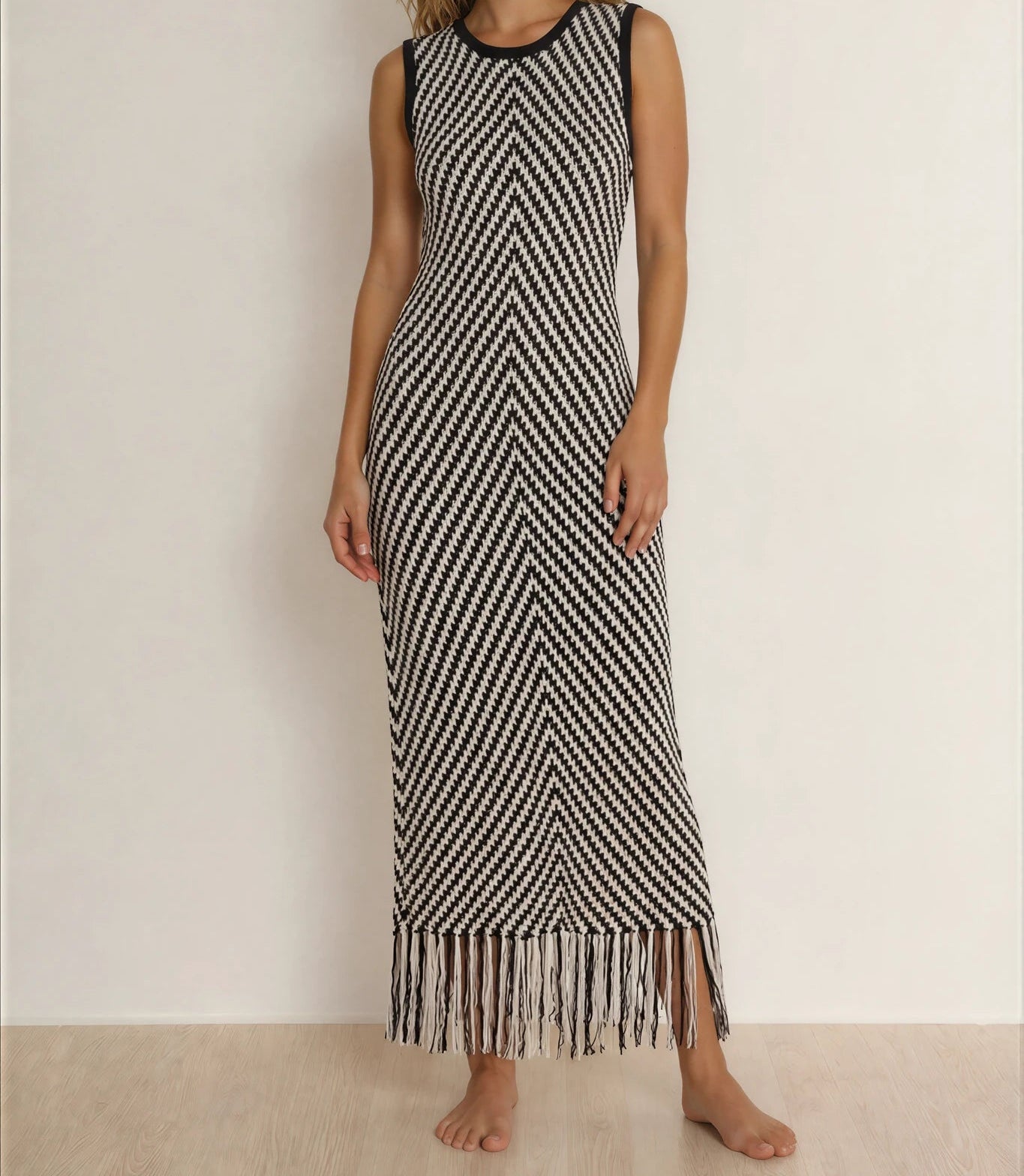 Model showing the front view of the Indi Luxe monochrome knit dress, showing the fringe hemline