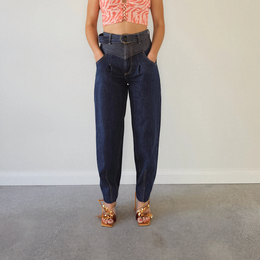  The front view of a woman wearing the Kivari Adina Jeans in Indigo, showing the high waist, belted style and tapered leg.