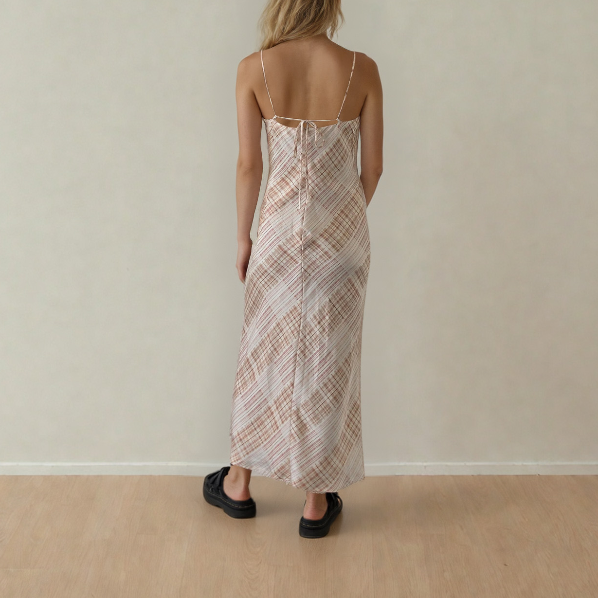 Image of woman wearing the checkmate slip dress, showing the the back adjustable tie and zip