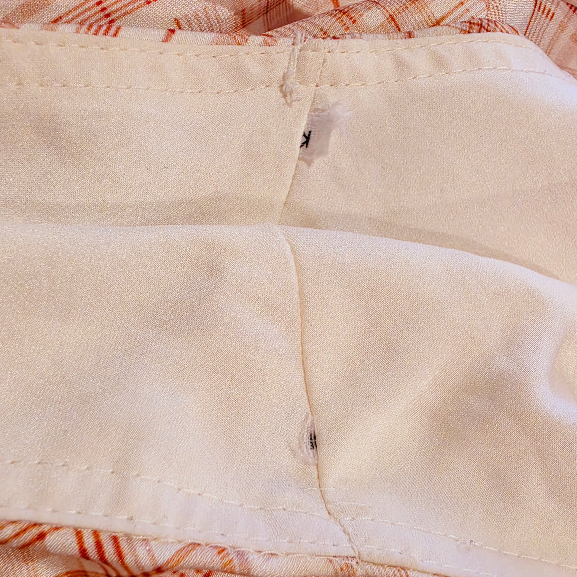 Close up view of the trimmed coat hanger tabs on the Kookai checkmate midi dress